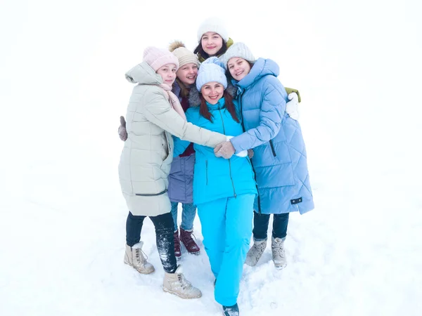 Grupo de hermosas chicas felices en ropa de invierno brillante de pie abrazando en un paseo en invierno — Foto de Stock