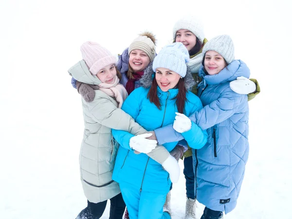 Familia feliz en invierno ropa brillante se coloca abrazando en un paseo en invierno — Foto de Stock