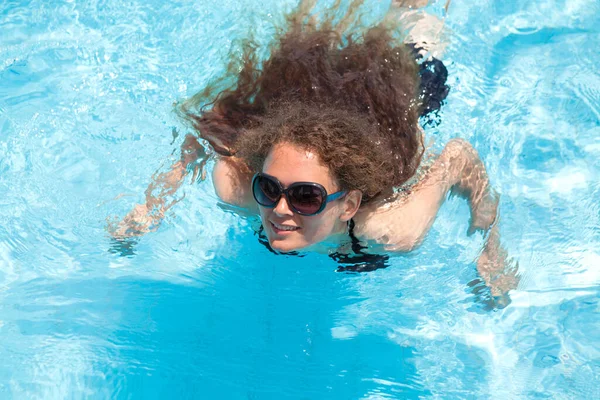 어느 여름날 수영장에서 선글라스를 쓴 곱슬머리의 아름다운 소녀의 모습. 리조트 — 스톡 사진