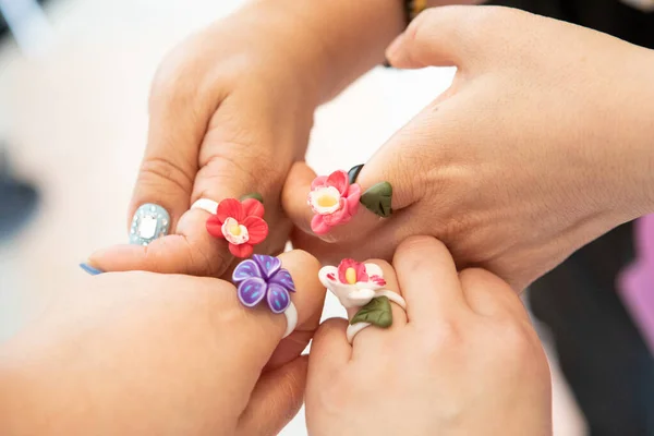 Çiçek yüzükleri takan dört kişi parmaklarını birleştiriyor..