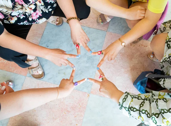 Beş kişi parmaklarını birleştirip V kılığına girdiler.