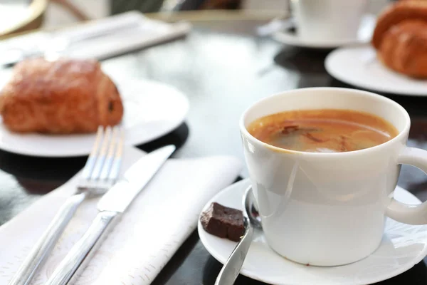 Sıcak kahve ve kruvasanla yatakta kahvaltı. Sağlıklı kahvaltı yatakta tutulur. Yataktaki tahta tepside kurabiyeli bir fincan çayı kapat..