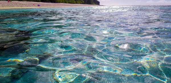 Deniz yüzeyinde ve altında deniz burnu, bulutlu mavi gökyüzü ve sualtı ile tropikal lagün sığ bir kumlu deniz yatağı, su hattı ile bölünmüş Pasifik okyanusu, Bora Bora, Fransız Polinezyası