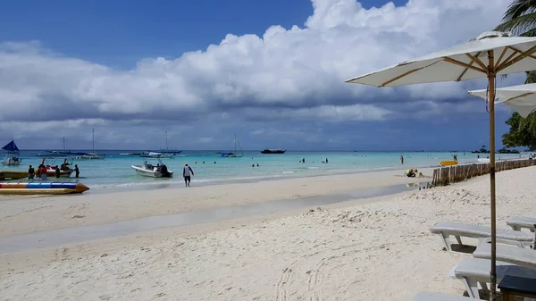 Mavi deniz ve kumsal şemsiyeleri.