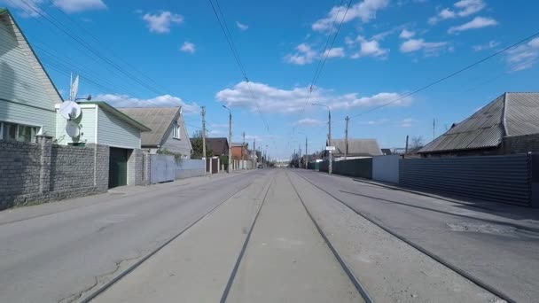 Vista, evin tramvay izleri olan boş bir cadde ve arkasında bulutlar olan mavi bir gökyüzü. — Stok video