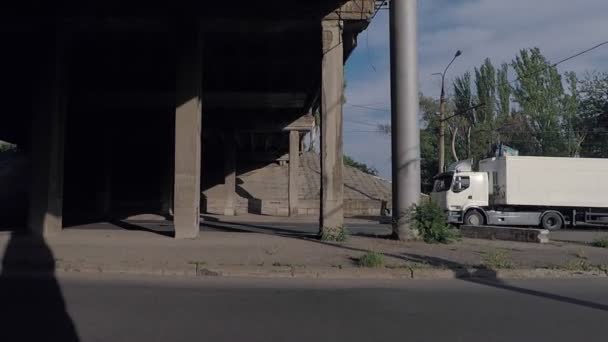 Carretera bajo el puente pasa camión y tractor — Vídeos de Stock