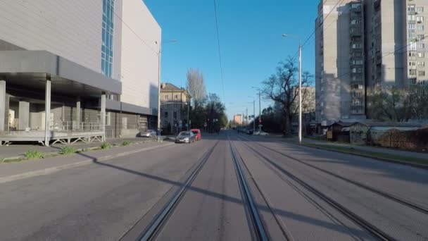 Пустая дорога во время карантина, улица с трамвайными путями, движение камеры вперед, фасады зданий против голубого неба — стоковое видео