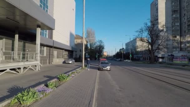 Cruzando un camino vacío durante la cuarentena, un cálido día soleado. Cielos despejados, gente pequeña en la calle, autoaislamiento — Vídeos de Stock