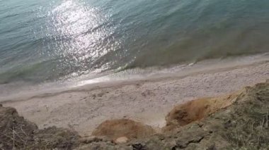 Uçurumdan denize ve sahile, parlak ışık ve küçük dalgalar