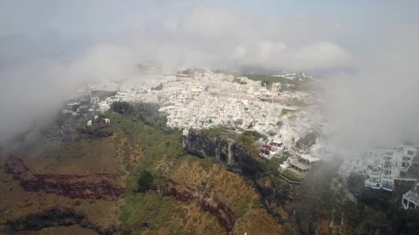 崖の上のサントリーニ島の建物空中ギリシャのホテル店プール低雲 — ストック動画