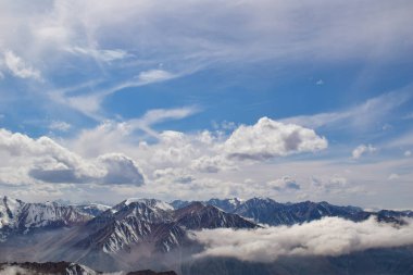 Gökyüzünün altındaki bulutlarda dağlar