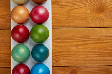 Ahşap zemin üzerinde renkli paskalya yumurtaları, metin için boş alan