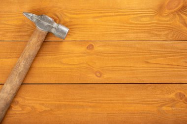 Tahta arka planda tahta saplı demir çekiç, boşluğu kopyala
