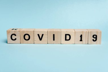 Mavi arkaplanda COVID-19 harfli tahta bloklar