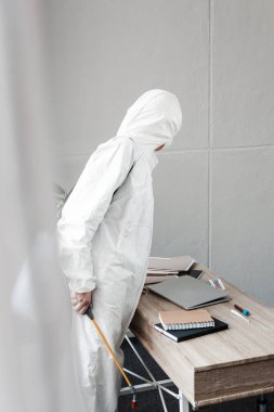 Beyaz tehlikeli madde giysisi, solunum cihazı ve gözlük takan kişi işyerinde dezenfekte etme, koronavirüs konsepti