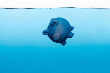 piggy bank going under blue water isolated on white, coronavirus crisis concept clipart