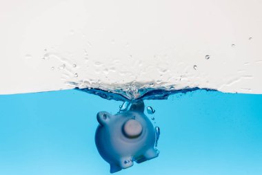 piggy bank going under blue water with splash isolated on white, coronavirus crisis concept clipart