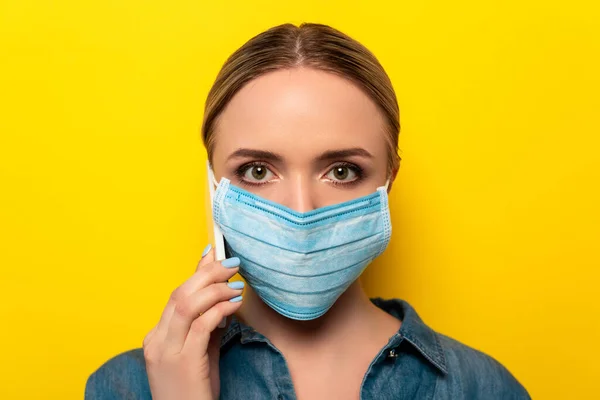 Young Woman Medical Mask Talking Smartphone Yellow Background — Stock Photo, Image