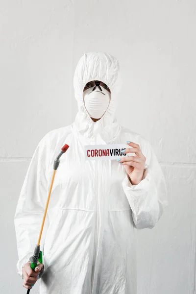 Persona Tuta Hazmat Bianca Respiratore Occhiali Con Disinfezione Coronavirus Card — Foto stock gratuita