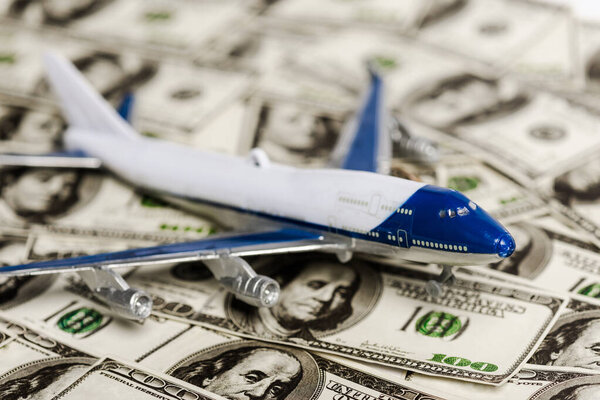 selective focus of plane model on dollar banknotes, coronavirus economic crisis concept