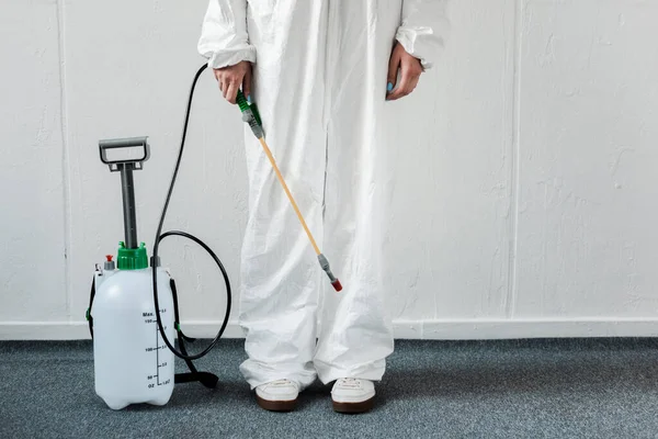 Vue recadrée de la personne en costume Hazmat blanc avec désinfection au bureau, concept de coronavirus — Photo de stock