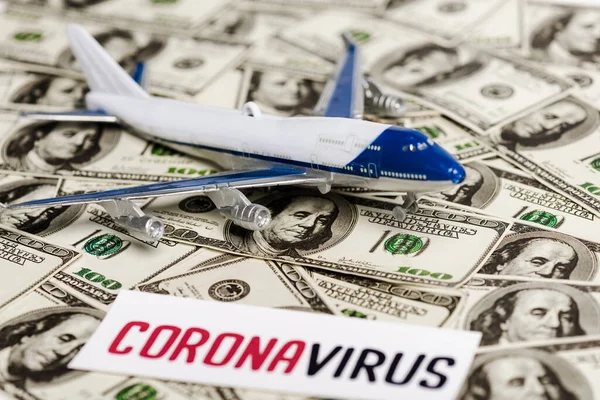 Focalizzazione selettiva della carta coronavirus e del modello aereo sulle banconote in dollari, concetto di crisi economica — Foto stock