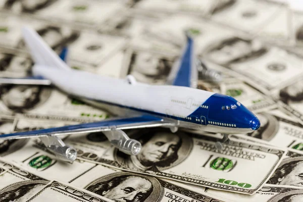 Enfoque selectivo del modelo de avión en billetes de dólar, concepto de crisis económica coronavirus - foto de stock