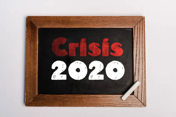 Crise 2020 lettrage écrit sur tableau sur fond blanc, concept coronavirus — Photo de stock