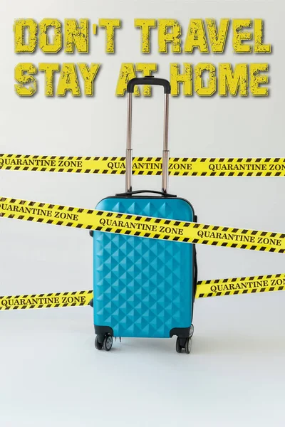 Blue suitcase in yellow and black hazard warning safety tape on white, do not travel, stay at home illustration — Stock Photo