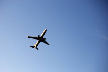 Mavi gökyüzünün arka planında bir uçak. Uçak iniyor. Uçak kalkıyor..