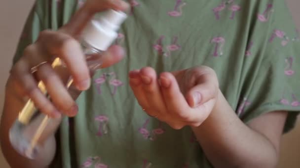 这个女孩用喷雾剂的形式用清洁剂消毒双手。手靠紧. — 图库视频影像