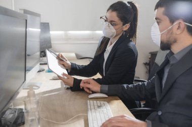 Coronavirus Ofis çalışanları Corona virüsü için maske takıyor. İş adamları sağlıklarını korumak ve korumak için maske takarlar. Ofis bilgisayarla çalışıyor. Evden çalışmak. 