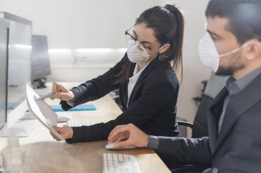 Coronavirus Ofis çalışanları Corona virüsü için maske takıyor. İş adamları sağlıklarını korumak ve korumak için maske takarlar. Ofis bilgisayarla çalışıyor. Evden çalışmak. 