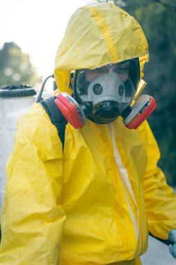 Coronavirus. Maske takıp sokakları temizleyen bir temizlik işçisi. Şehirdeki dezenfekte edilmiş şehirleri sterilize et. Coronavirüs 'e karşı dezenfekte. Kıyafet koruması. 
