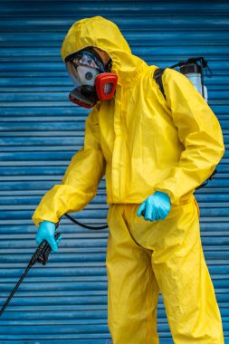 Coronavirus. Maske takıp sokakları temizleyen bir temizlik işçisi. Şehirdeki dezenfekte edilmiş şehirleri sterilize et. Coronavirüs 'e karşı dezenfekte. Kıyafet koruması. 