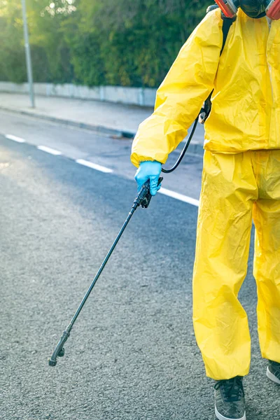 Coronavirus. A sanitation worker wearing a mask and cleaning the streets. Sterilize urban decontaminate city. Disinfecting against to the Coronavirus. Suit protection.