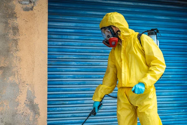 Coronavirus. A sanitation worker wearing a mask and cleaning the streets. Sterilize urban decontaminate city. Disinfecting against to the Coronavirus. Suit protection.