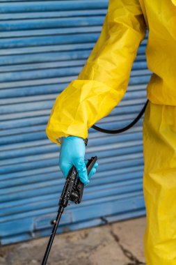 Coronavirus. Maske takıp sokakları temizleyen bir temizlik işçisi. Şehirdeki dezenfekte edilmiş şehirleri sterilize et. Coronavirüs 'e karşı dezenfekte. Kıyafet koruması. 
