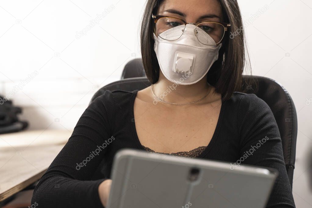 Coronavirus. Woman at the office sick with mask for corona virus. Business women wear masks to protect and take care of their health. Home working with computer. Working from home. 