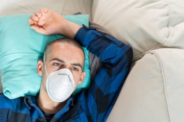 Coronavirus. Evde koruyucu maske takan bir adam. Koronavirüs yüzünden karantinaya alınan kadın ellerini dezenfektan jeliyle temizliyor. Evden çalışıyorum. Ellerini dezenfektan jeliyle temizle.. 