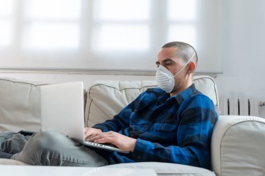 Coronavirus. Evde koruyucu maske takan bir adam. Koronavirüs yüzünden karantinaya alınan kadın ellerini dezenfektan jeliyle temizliyor. Evden çalışıyorum. Ellerini dezenfektan jeliyle temizle.. 