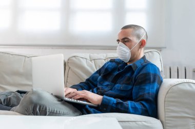 Coronavirus. Evde koruyucu maske takan bir adam. Koronavirüs yüzünden karantinaya alınan kadın ellerini dezenfektan jeliyle temizliyor. Evden çalışıyorum. Ellerini dezenfektan jeliyle temizle.. 