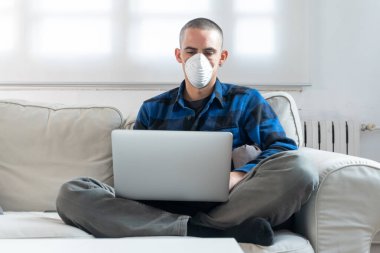 Coronavirus. Evde koruyucu maske takan bir adam. Koronavirüs yüzünden karantinaya alınan kadın ellerini dezenfektan jeliyle temizliyor. Evden çalışıyorum. Ellerini dezenfektan jeliyle temizle.. 