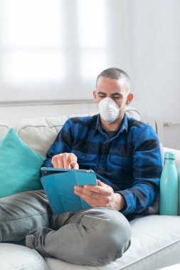 Coronavirus. Evde koruyucu maske takan bir adam. Koronavirüs yüzünden karantinaya alınan kadın ellerini dezenfektan jeliyle temizliyor. Evden çalışıyorum. Ellerini dezenfektan jeliyle temizle.. 
