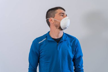 Coronavirus. COVID-19. Karantina sırasında maskeli genç adam evde spor yapıyor. Ev aktivitelerinde kal. Pandemiden enfeksiyonu önlemek için. Evde sağlıklı.. 