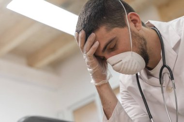 Koronavirüs salgını. Hastane kliniğinde Coronavirus 'la (2019-nCoV) uzun vardiya savaşından sonra yorgun düşmüş doktor. Dünya çapında küresel SARS-CoV-2 salgını.