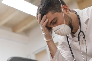Koronavirüs salgını. Hastane kliniğinde Coronavirus 'la (2019-nCoV) uzun vardiya savaşından sonra yorgun düşmüş doktor. Dünya çapında küresel SARS-CoV-2 salgını.