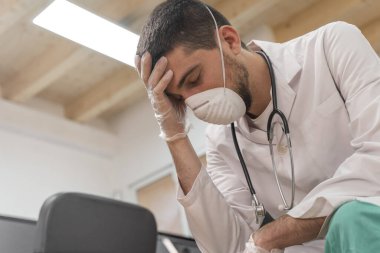 Koronavirüs salgını. Hastane kliniğinde Coronavirus 'la (2019-nCoV) uzun vardiya savaşından sonra yorgun düşmüş doktor. Dünya çapında küresel SARS-CoV-2 salgını.