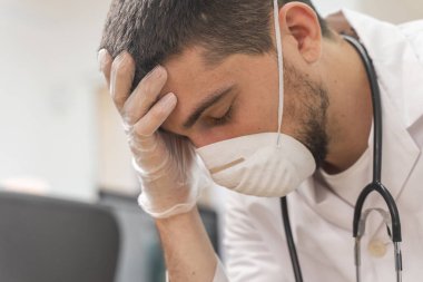 Koronavirüs salgını. Hastane kliniğinde Coronavirus 'la (2019-nCoV) uzun vardiya savaşından sonra yorgun düşmüş doktor. Dünya çapında küresel SARS-CoV-2 salgını.
