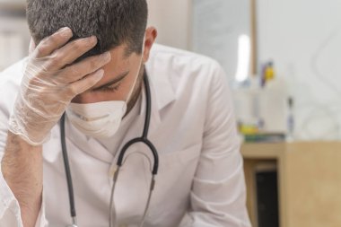 Koronavirüs salgını. Hastane kliniğinde Coronavirus 'la (2019-nCoV) uzun vardiya savaşından sonra yorgun düşmüş doktor. Dünya çapında küresel SARS-CoV-2 salgını.
